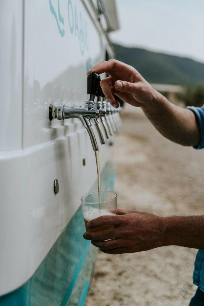 Grifo de cerveza de El Oasis Nomada llenando un vaso en el exterior de una casa rural en Bullas durante la celebracion de una boda