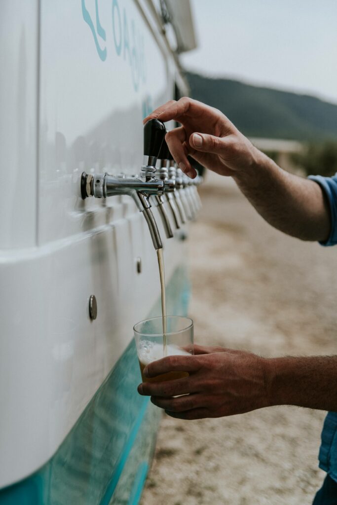 Primer plano de cerveza siendo servida en un vaso desde uno de los grifos de nuestra furgoneta-bar